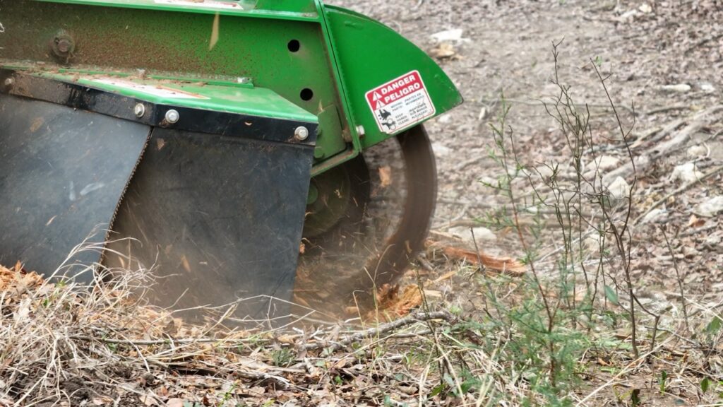 S.A. Total Tree Service performing professional stump grinding in San Antonio, TX, removing a tree stump efficiently with specialized equipment.